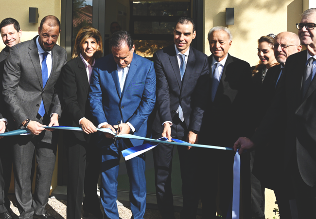 A group of individuals cutting a ribbon during an inauguration event.