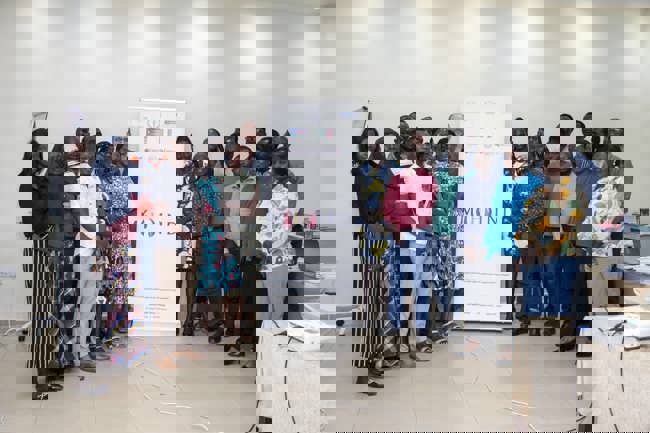 A group of individuals standing in front of a banner at an event.